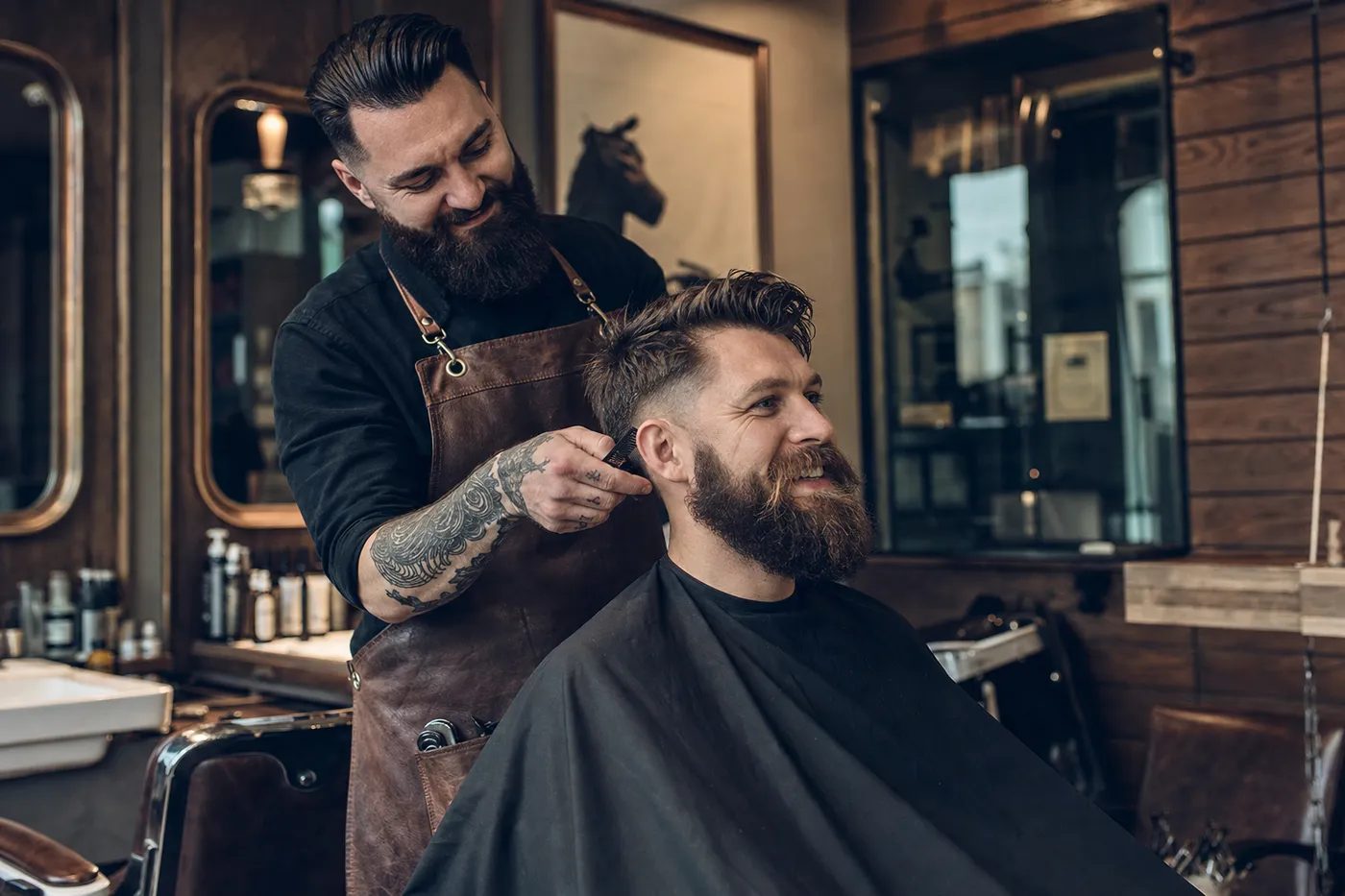 Barbero dando un corte a un cliente satisfecho en una barbería moderna